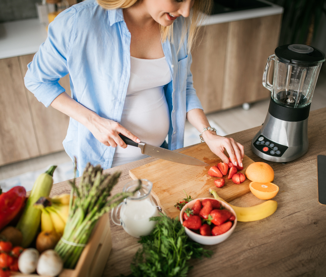 Pregnant woman preparing fruits and vegetables to put in a blender